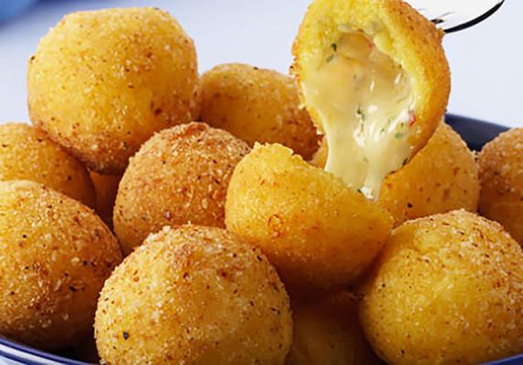 Golden crumbed cheese balls, with one opened to show melted cheese filling
