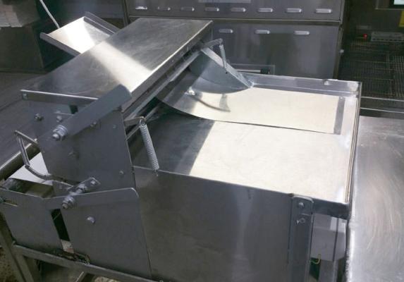 Stainless-steel commercial dough sheeter in a professional pizza kitchen