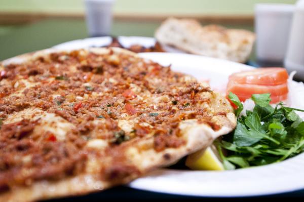 Lebanese meat pizza topped with minced meat, herbs and spices, served with parsley, lemon and tomato