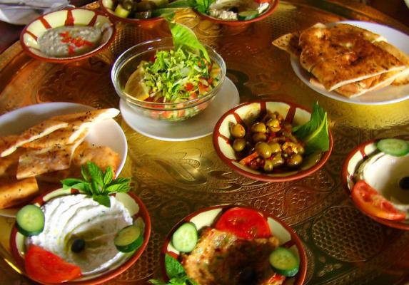 Colourful Lebanese mezze spread with hummus, tabouli, olives, flatbread and grilled dishes