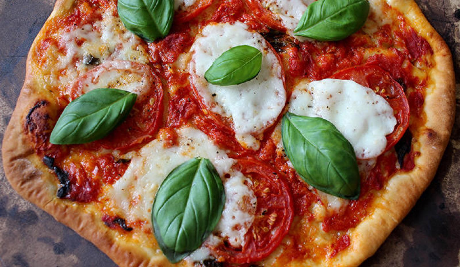 Fresh Margherita pizza with tomato sauce, melted mozzarella and basil leaves