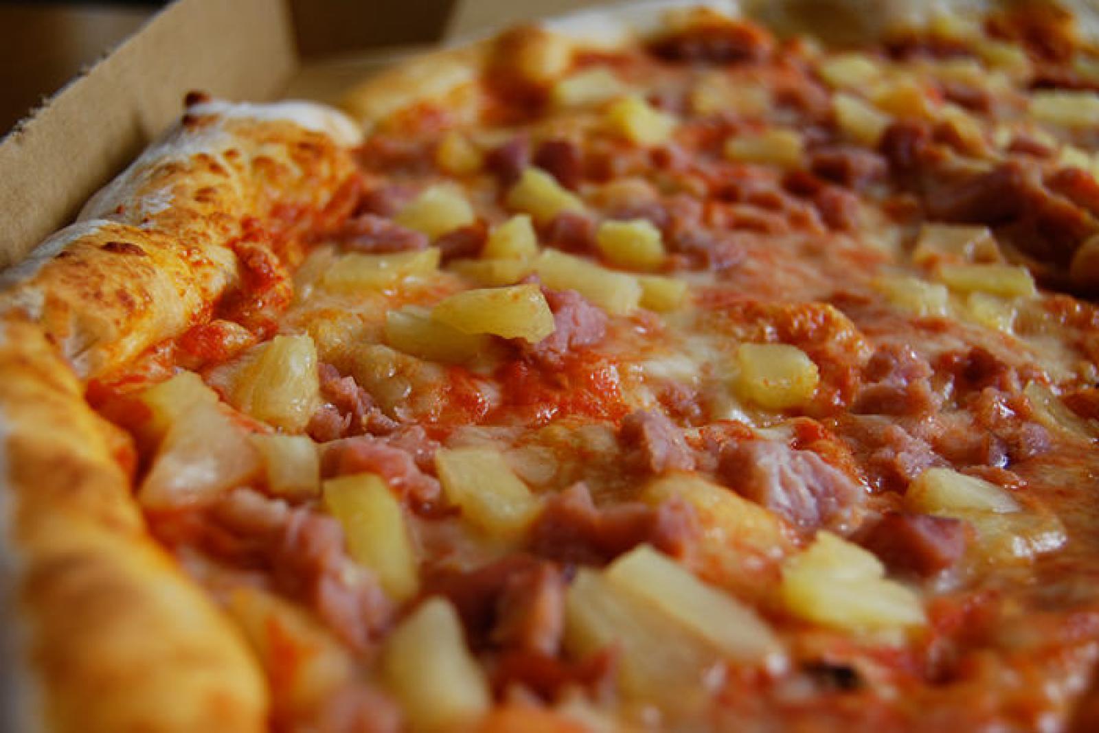 Close-up of a Hawaiian pizza with ham, pineapple, melted cheese and tomato sauce