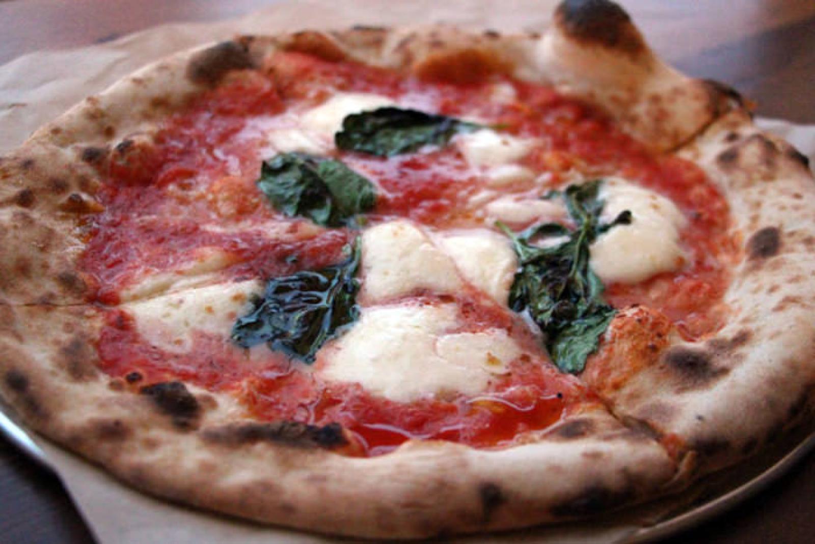 Wood-fired Margherita pizza with tomato sauce, fresh mozzarella and basil leaves