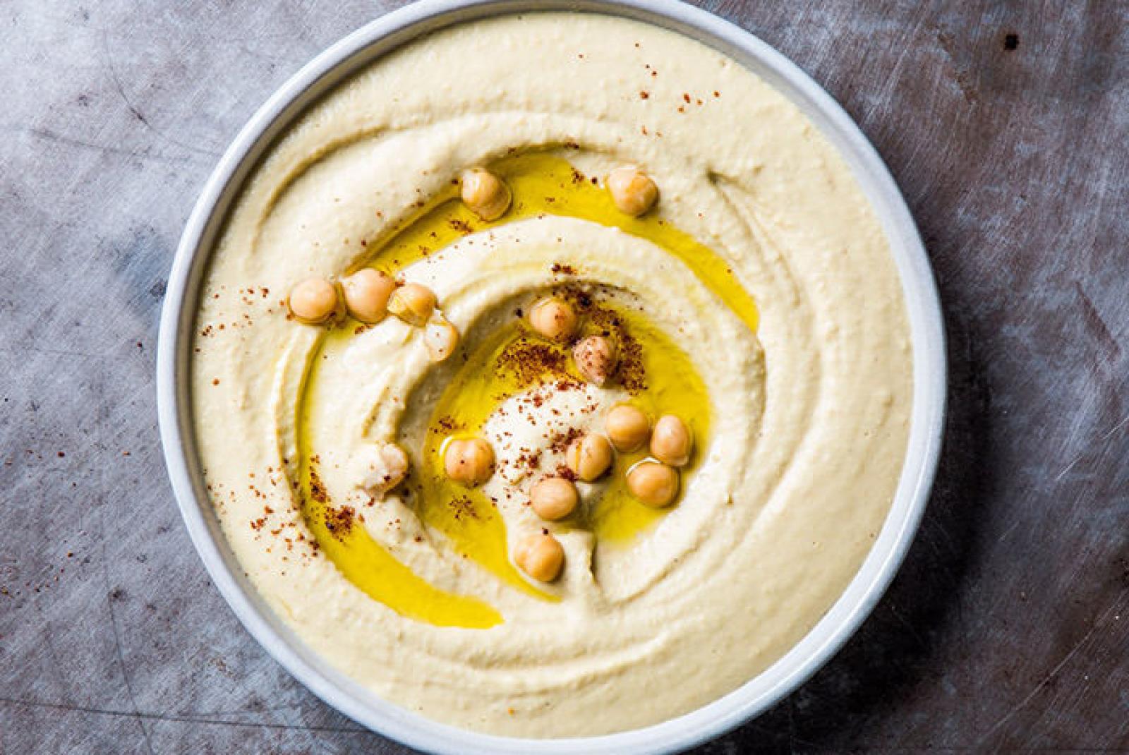 Bowl of creamy hommus topped with chickpeas, olive oil and spices