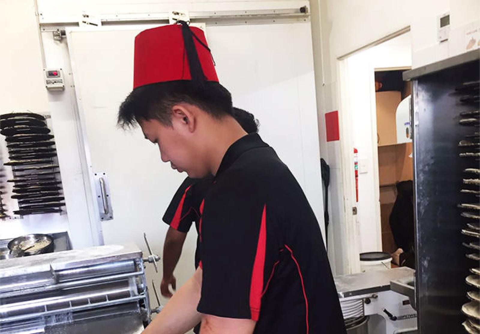 OOSHMAN team member preparing food in a commercial kitchen