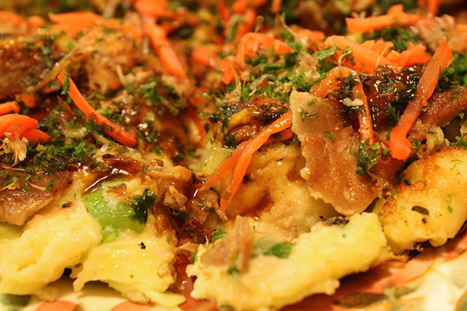 Close-up of Lebanese flatbread topped with spiced meat, herbs and shredded carrot