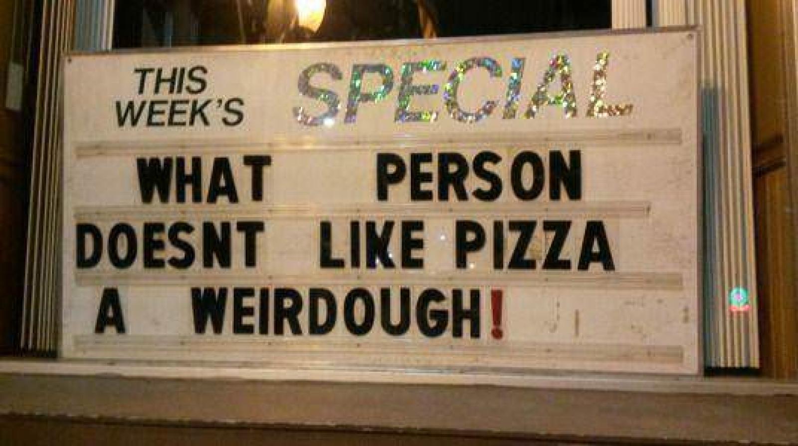 Illuminated shop sign reads, “What person doesn’t like pizza? A weirdough!”