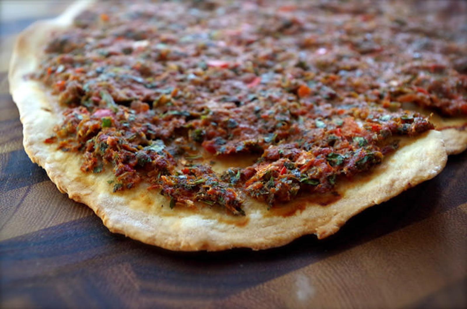 Close-up of a Lebanese lahembajin flatbread topped with seasoned minced meat and herbs