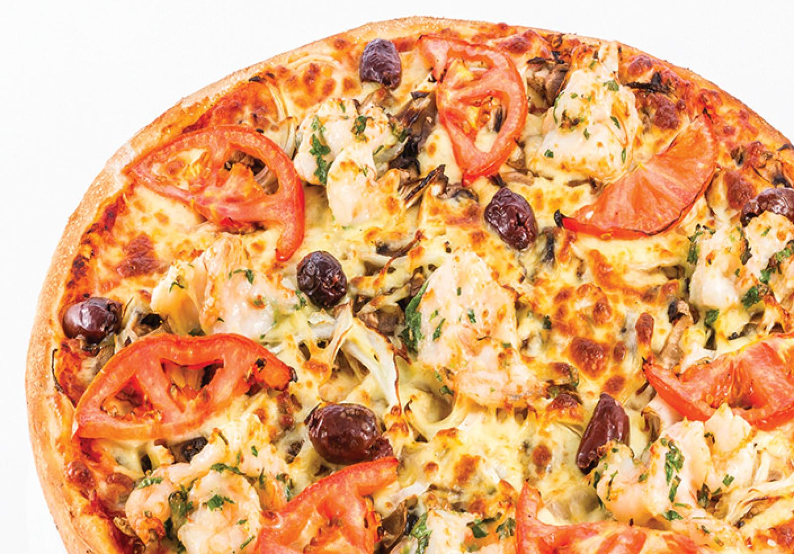 Vegetarian pizza topped with tomato slices, olives, cheese and herbs on a white background
