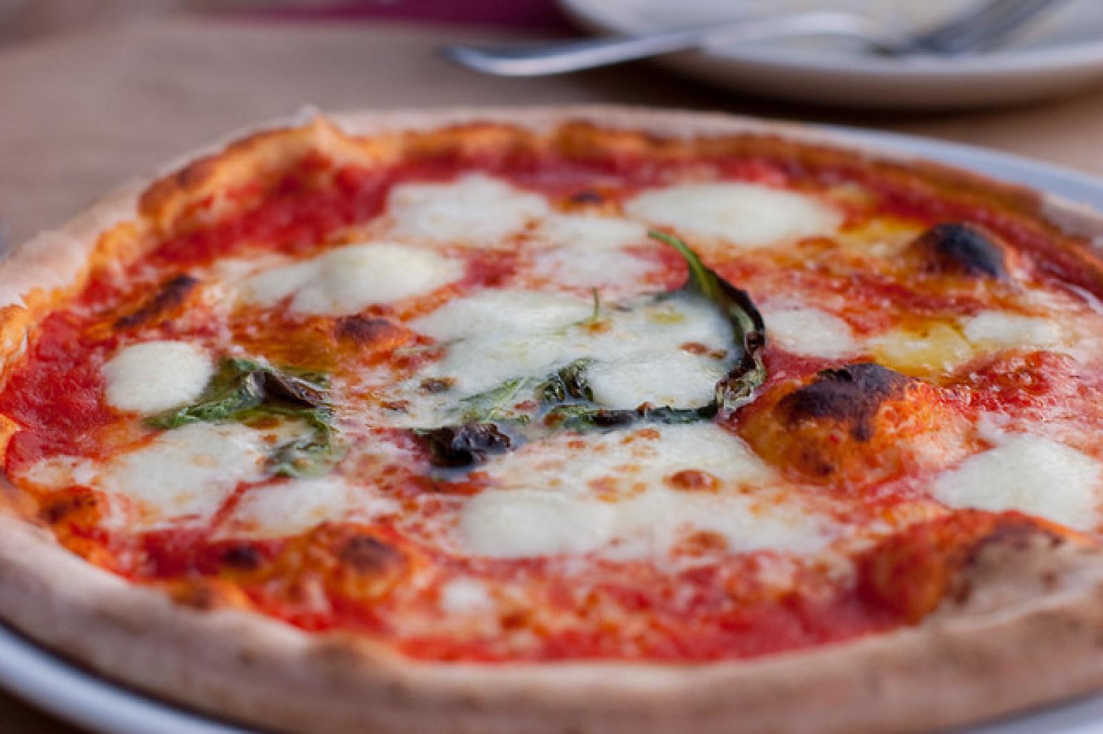 Close-up of a freshly baked margherita pizza with melted mozzarella, basil and tomato sauce
