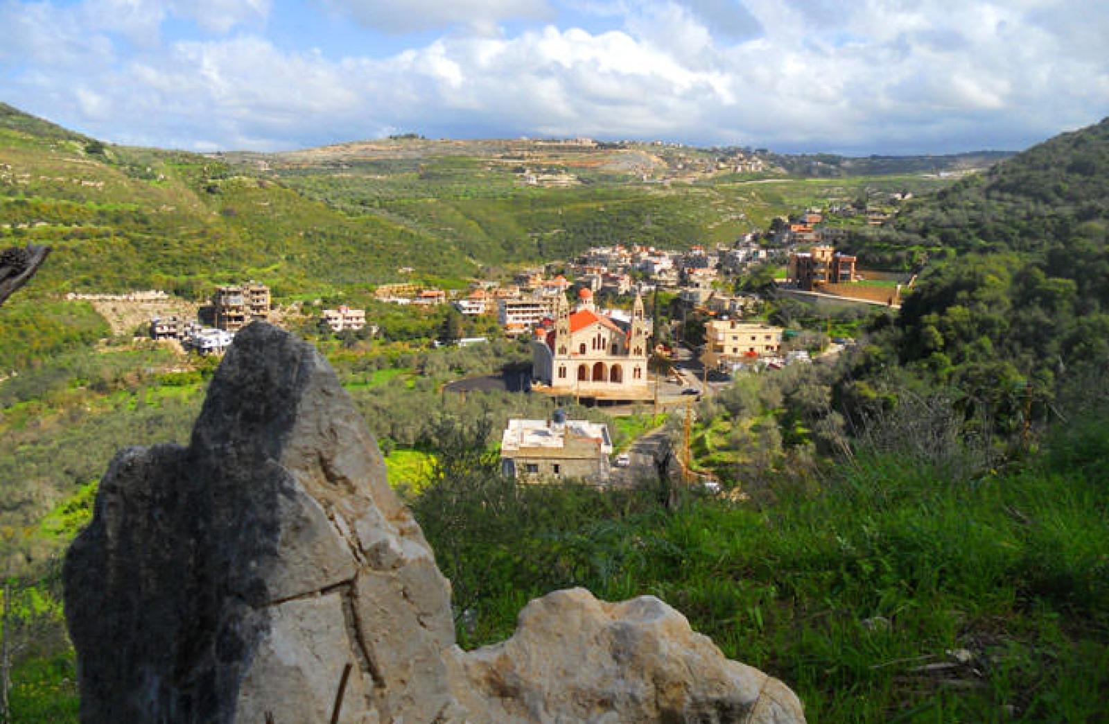 Rocky hillside overlooking a traditional village in the green Lebanese countryside