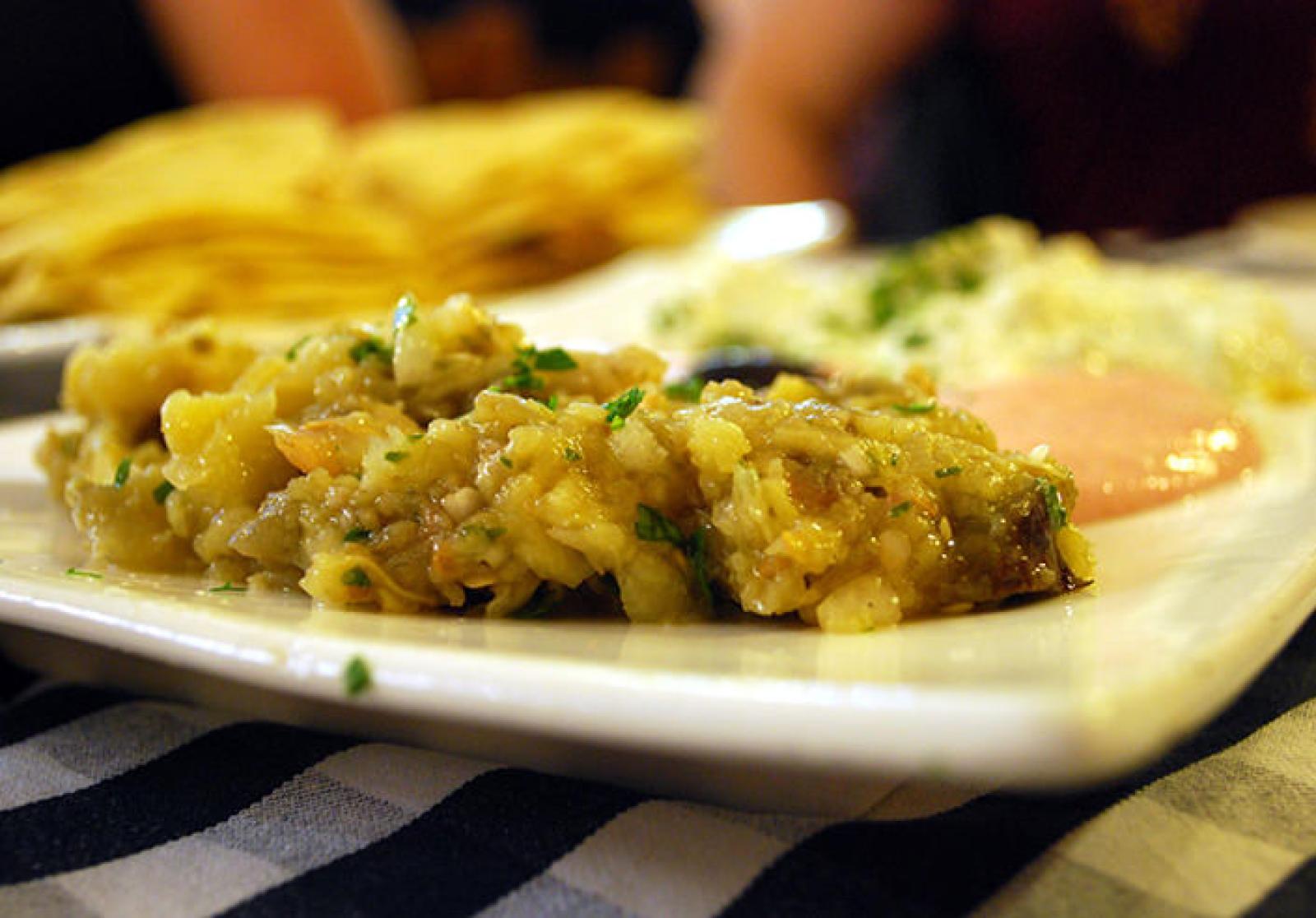 Plate of seasoned bulgur wheat beside eggs and Lebanese flatbread