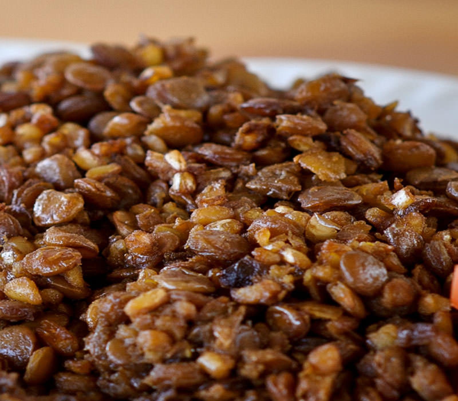 Close-up of seasoned brown lentils and grains on a white plate