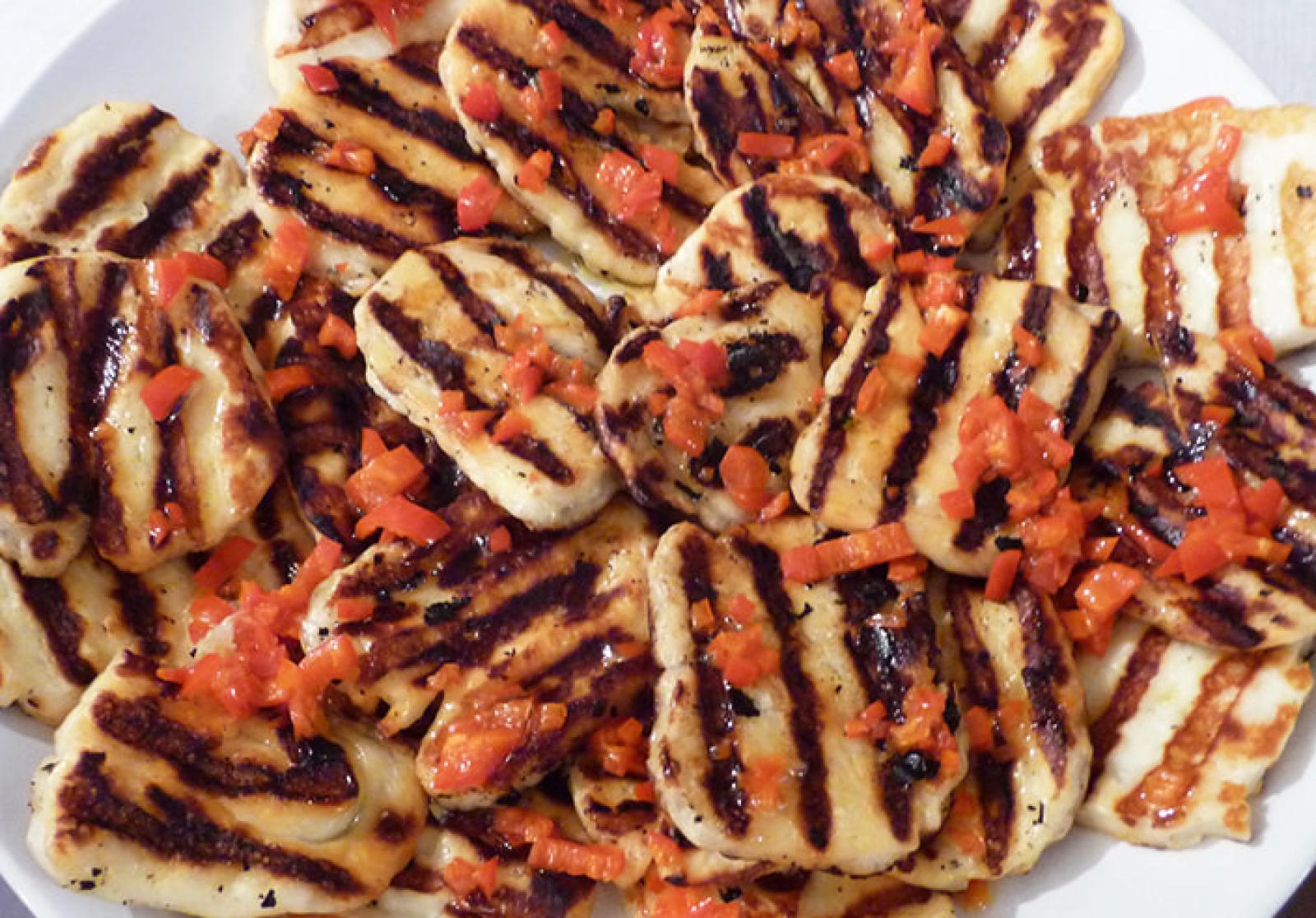 Grilled chicken pieces with char marks, herbs and a rich tomato-based sauce