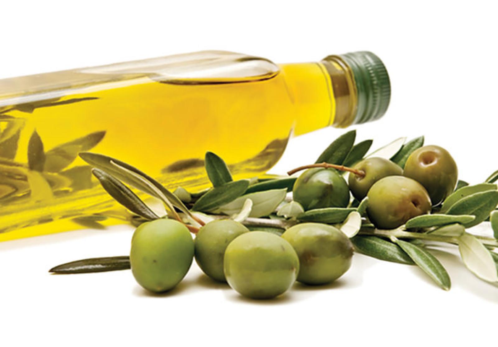 Bottle of olive oil with green olives and fresh olive branches on a white background