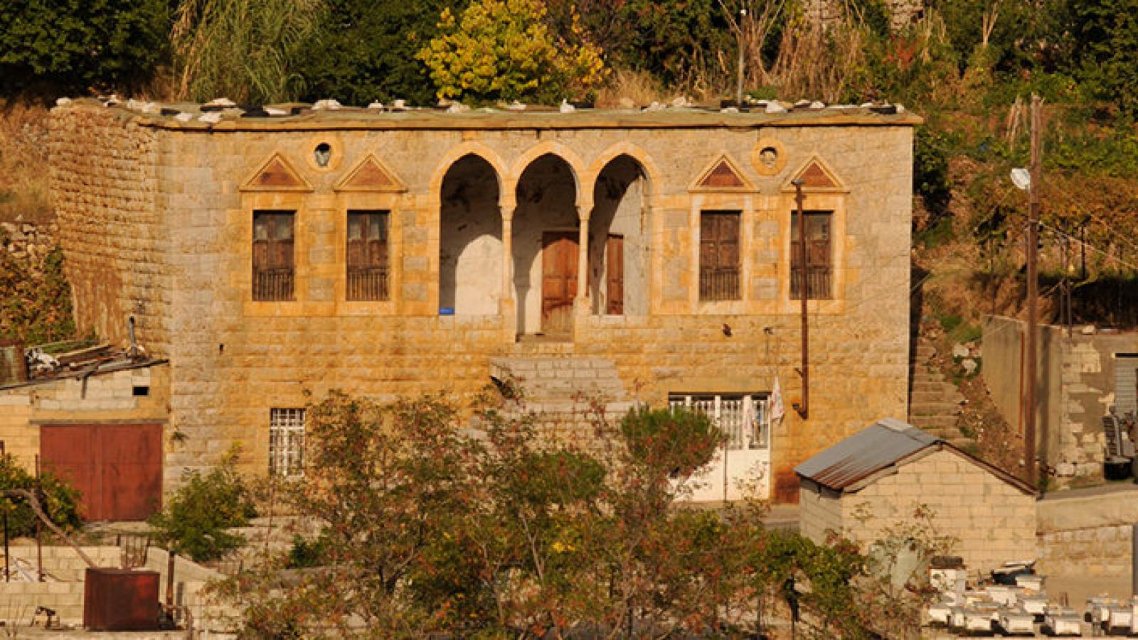 Traditional stone house with arched windows in a Lebanese village landscape
